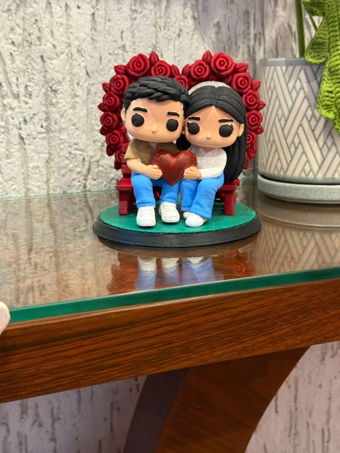 Figura 3D personalizada de una pareja sentada en una banca con corazón de rosas